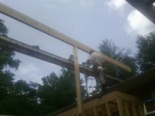 Carpenter setting a ridge beam over a new addition frame — Ice Dam Removal by Roofing Brothers in Sauk City