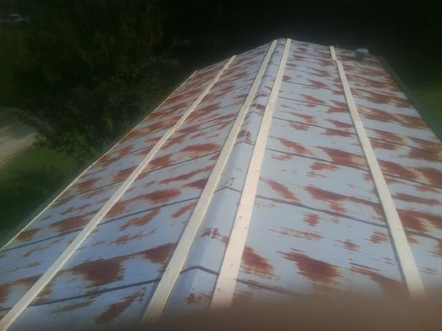 Rusted metal roof panels with new wood purlins before replacement — Storm Damage Roof Repair in Sauk City by Roofing Brothers
