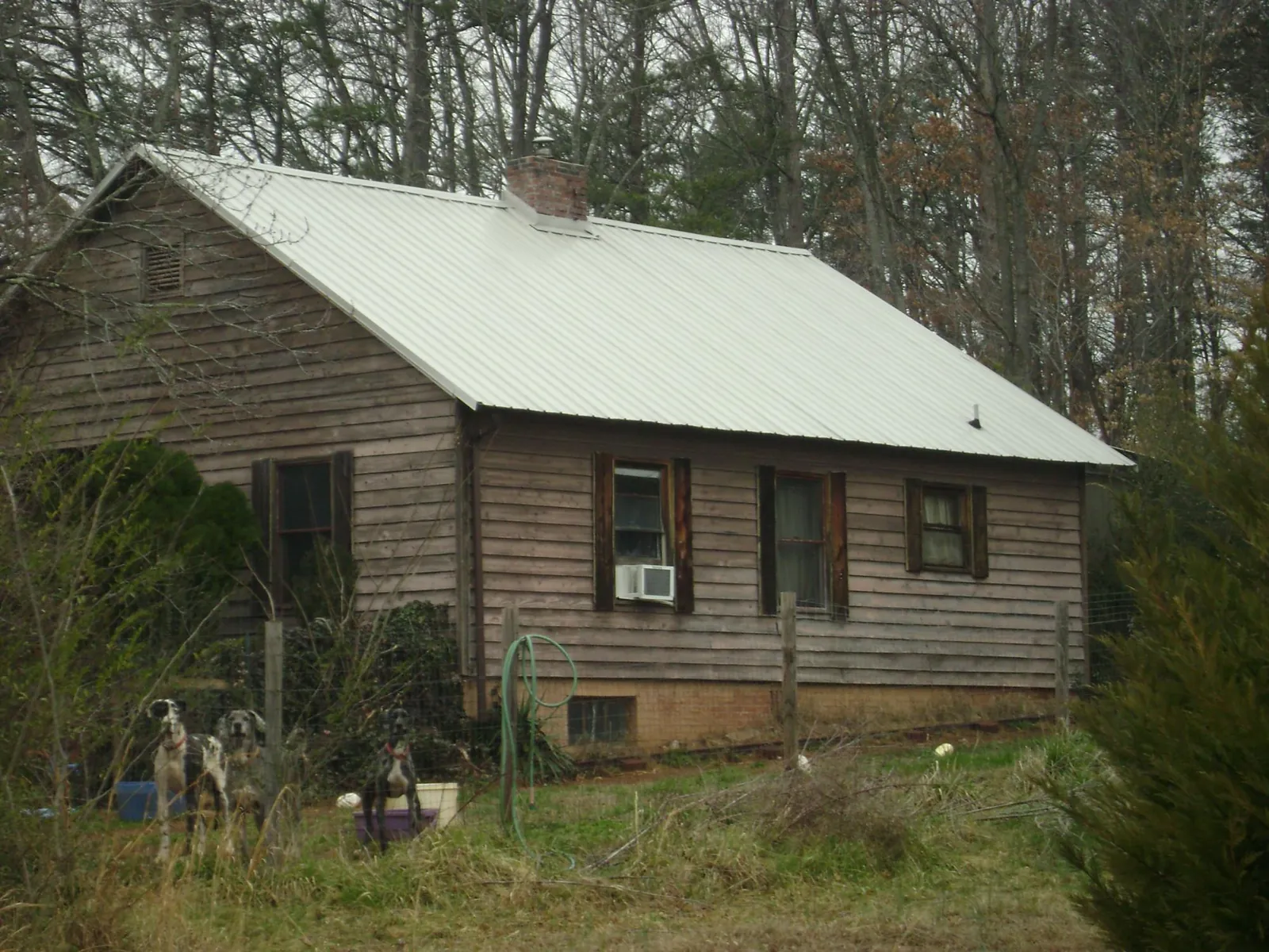 White metal roof on an old wood sided farmhouse, from a Metal Roof Installation job in Sauk City